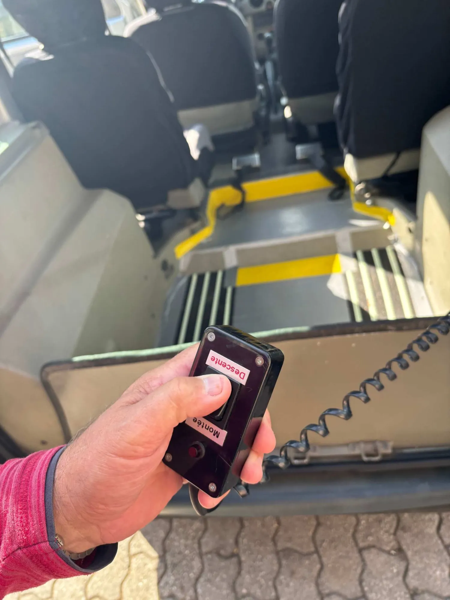 Handy mit geöffneter Taxi-App im Innenraum eines Fahrzeugs mit Rollstuhlrampe.