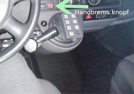 Instrumententafel eines Fahrzeugs mit Lenkrad und Handbremshebel.