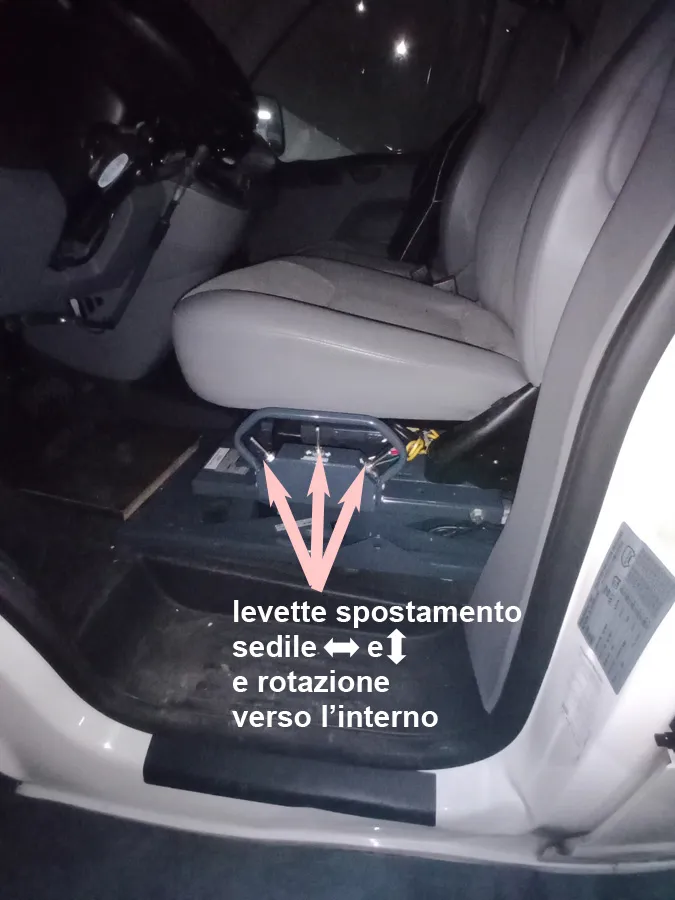 Autositz mit Sicherheitsgurt und Fußmatte in einem dunklen Fahrzeuginnenraum.