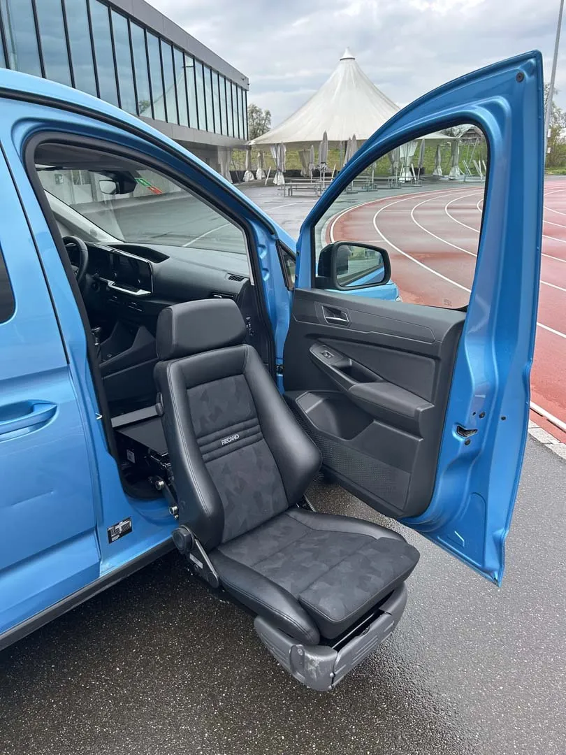 Blauer Kleinwagen mit ausklappbarem Autositz für erleichterten Einstieg.