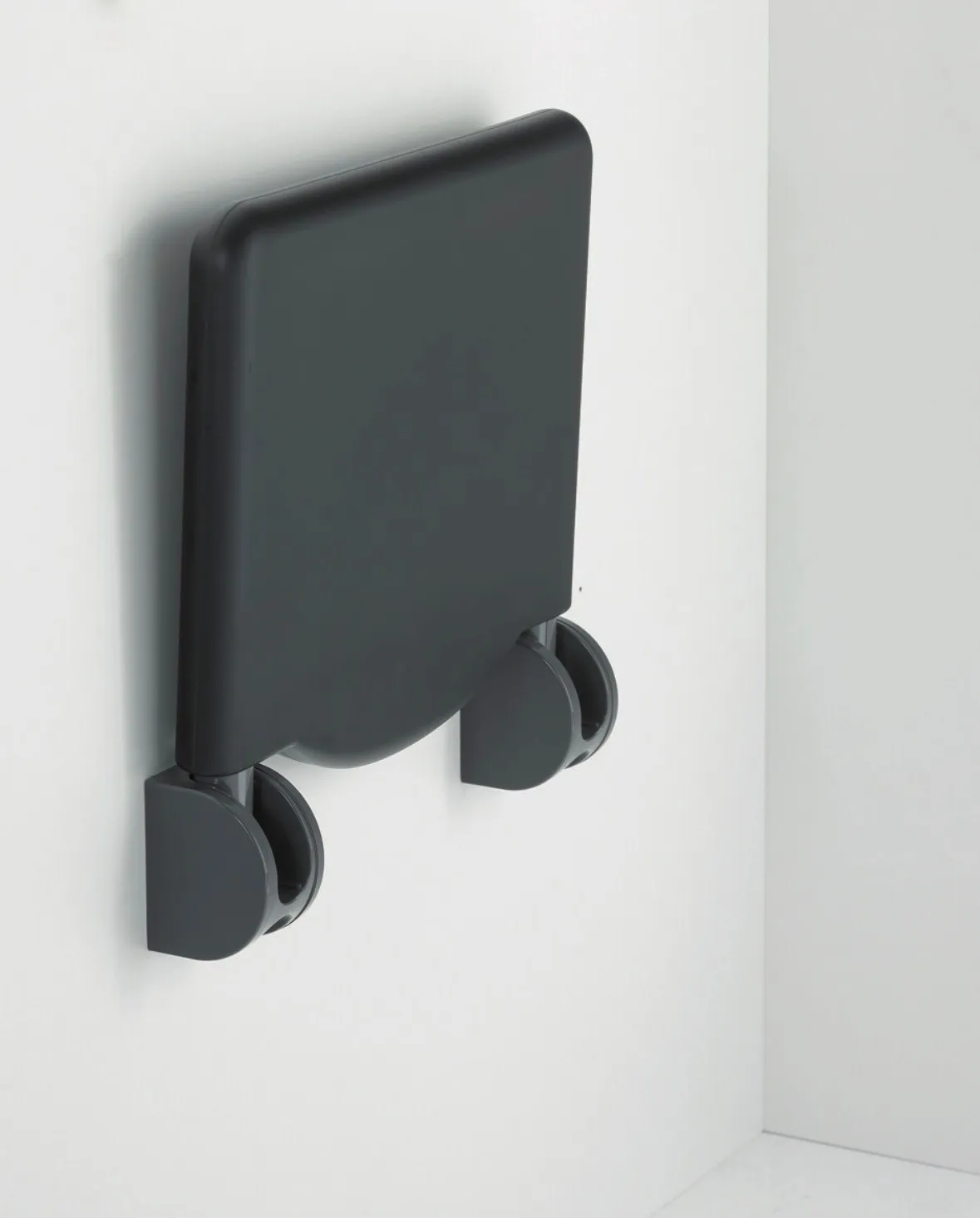 occasion-normbau-duschsitz-lippuner-05.jpg Schwarzer, klappbarer Wandsitz für die Dusche, an der Wand montiert.