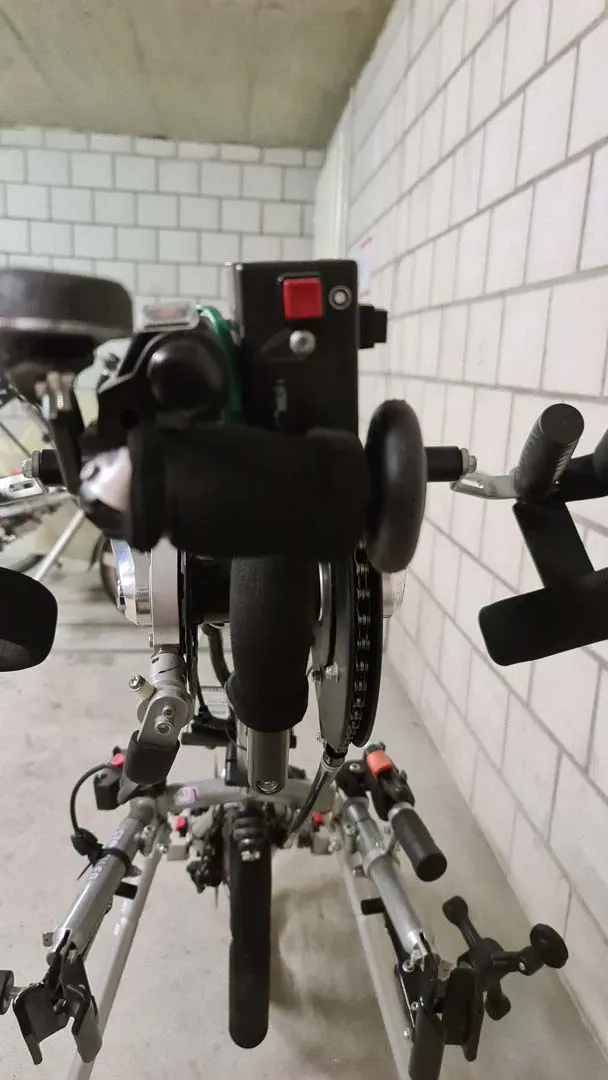 occasion-stricker-vorspannbike-nguyen-03.jpg Schwarzer Roboter mit roten Augen in einem weißgefliesten Raum.
