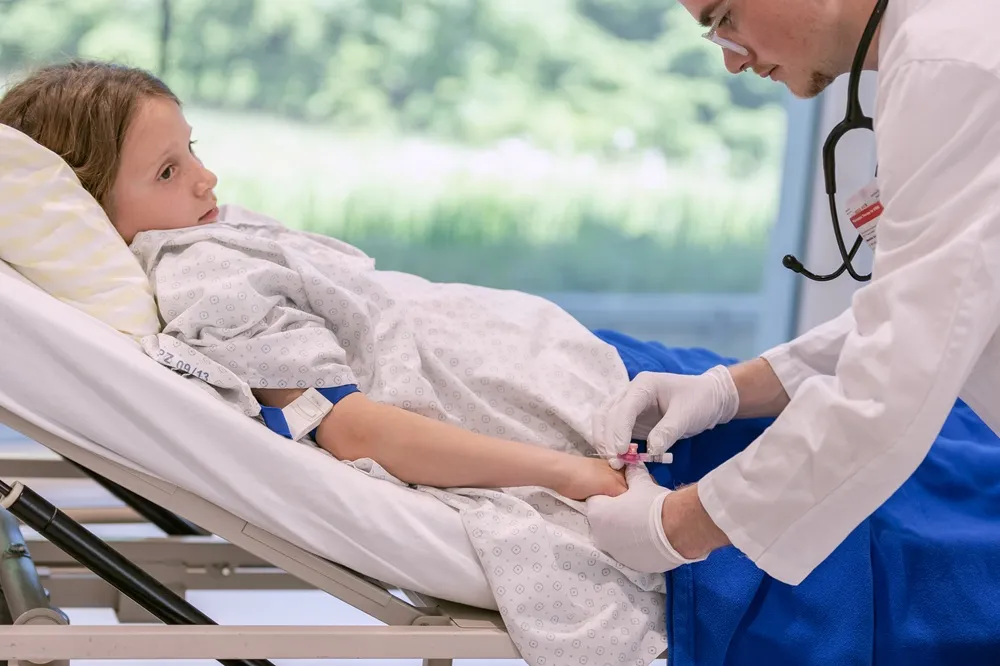 Doctor examining young patient in reclining chair, medical setting