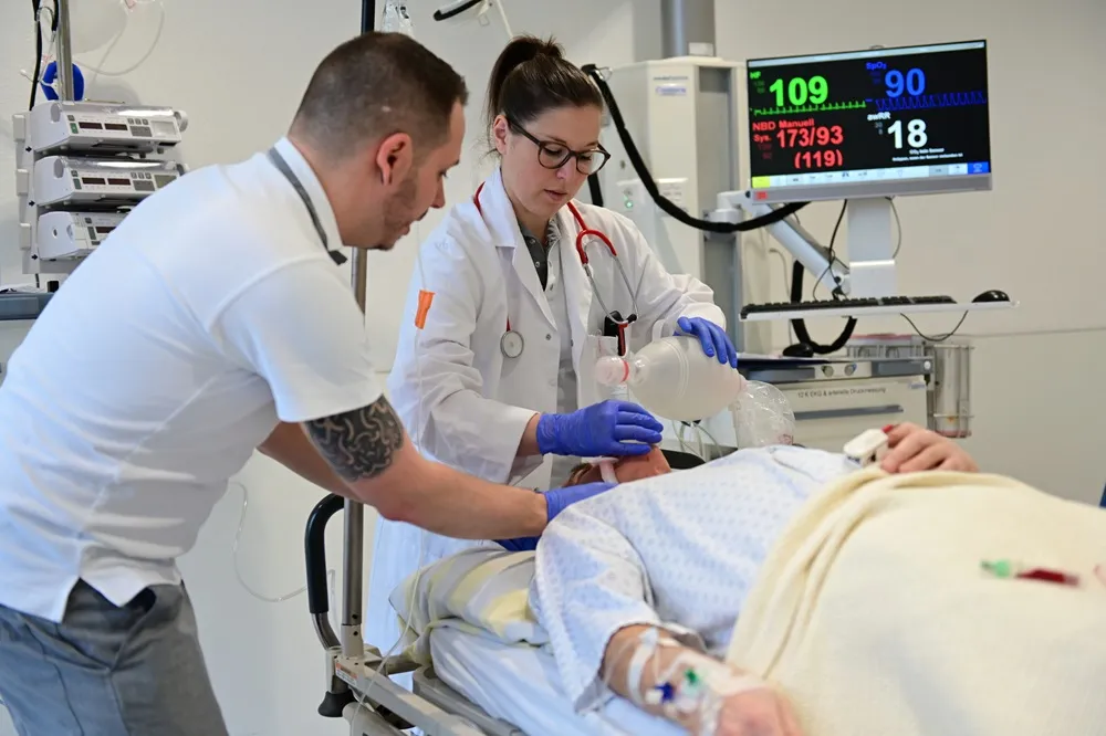 Medical professionals examining patient on hospital bed with monitoring equipment