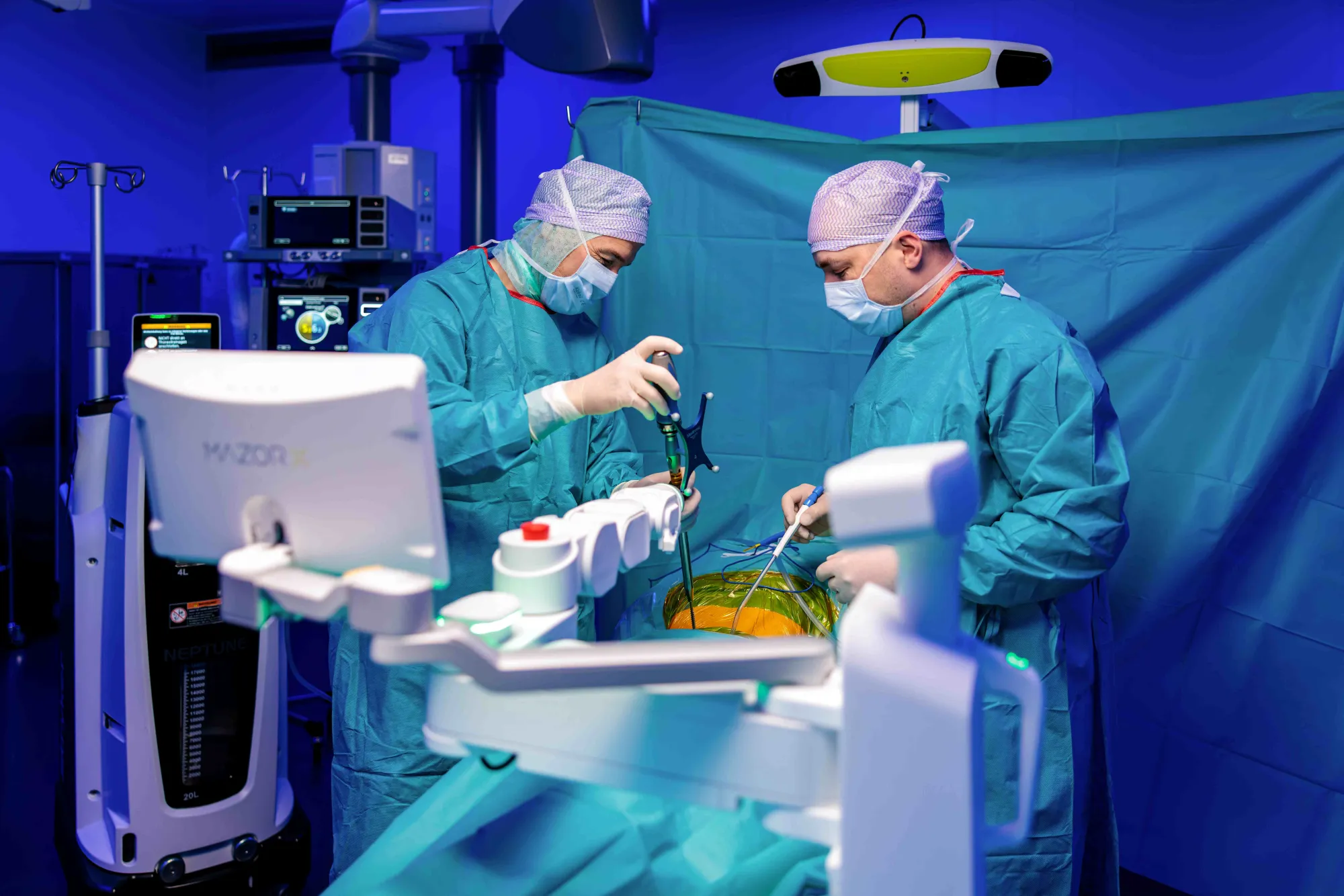 Una fotografia di due medici che eseguono un intervento chirurgico in una sala operatoria.
