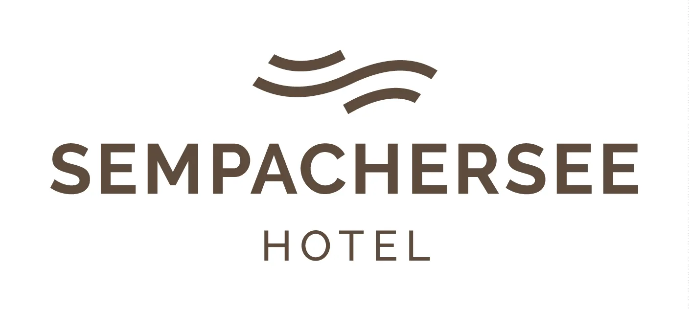 Scenic mountain hotel with Swiss Alps backdrop and pine forest surroundings.