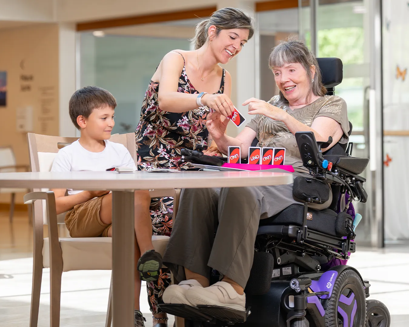 An elderly woman playing while her daughter assists her.