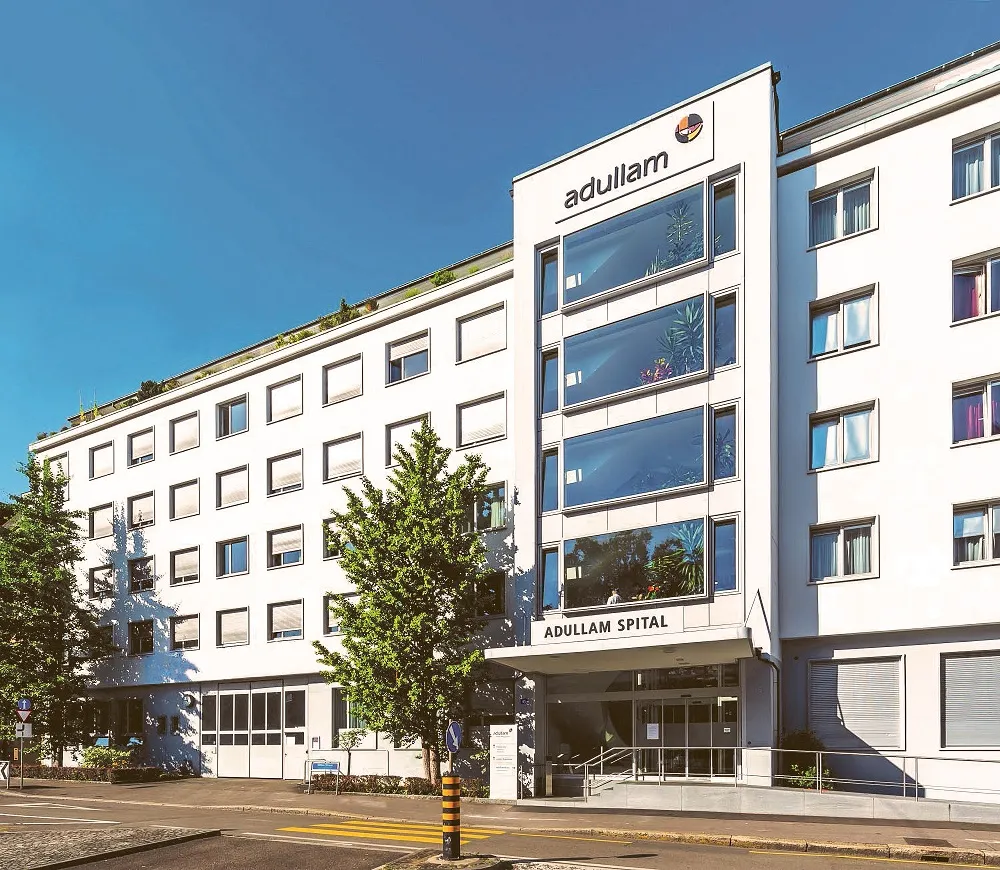 A modern multi-story office building with a Pullman Hotels sign at the top.