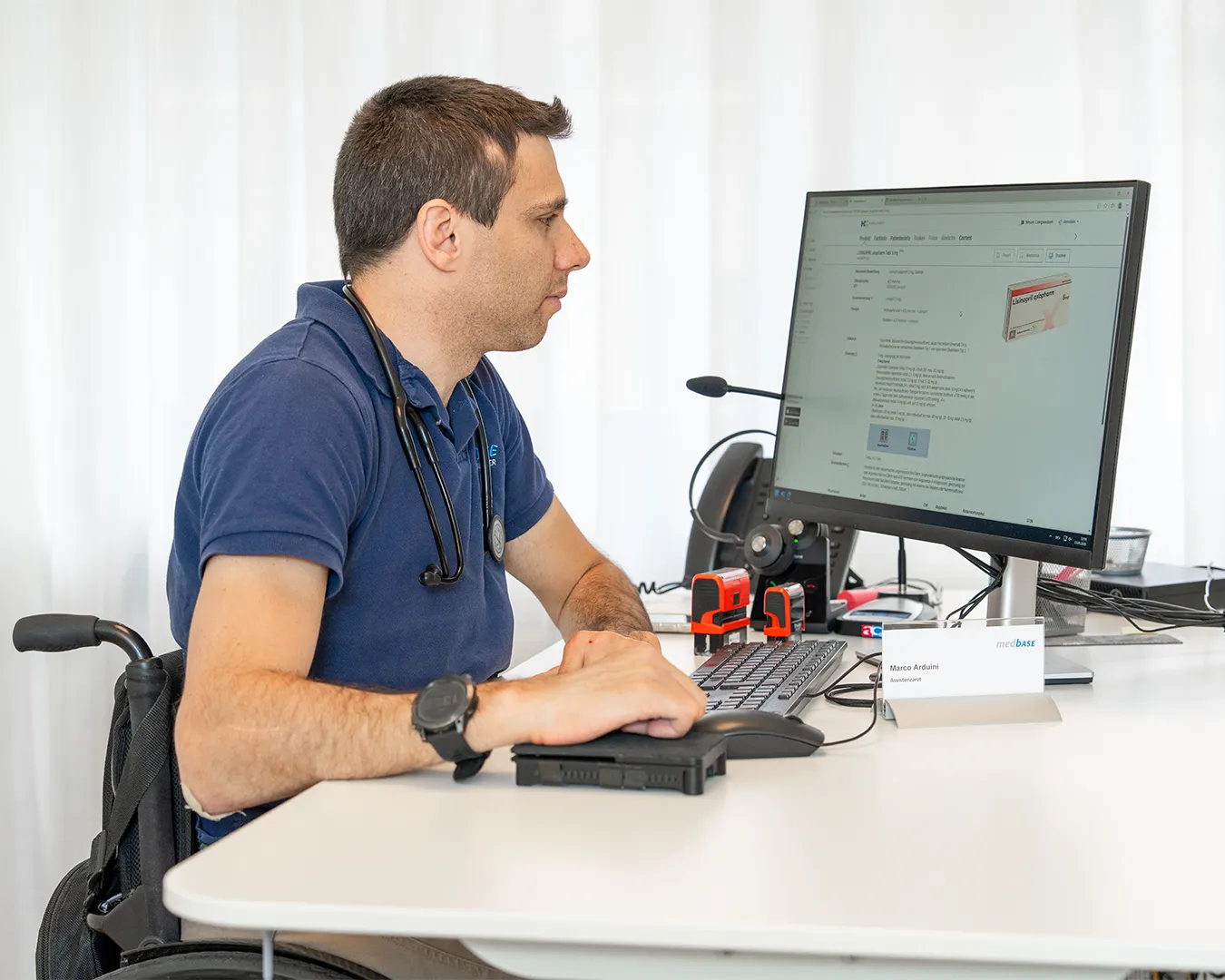 A man sitting at a desk, working on a computer.