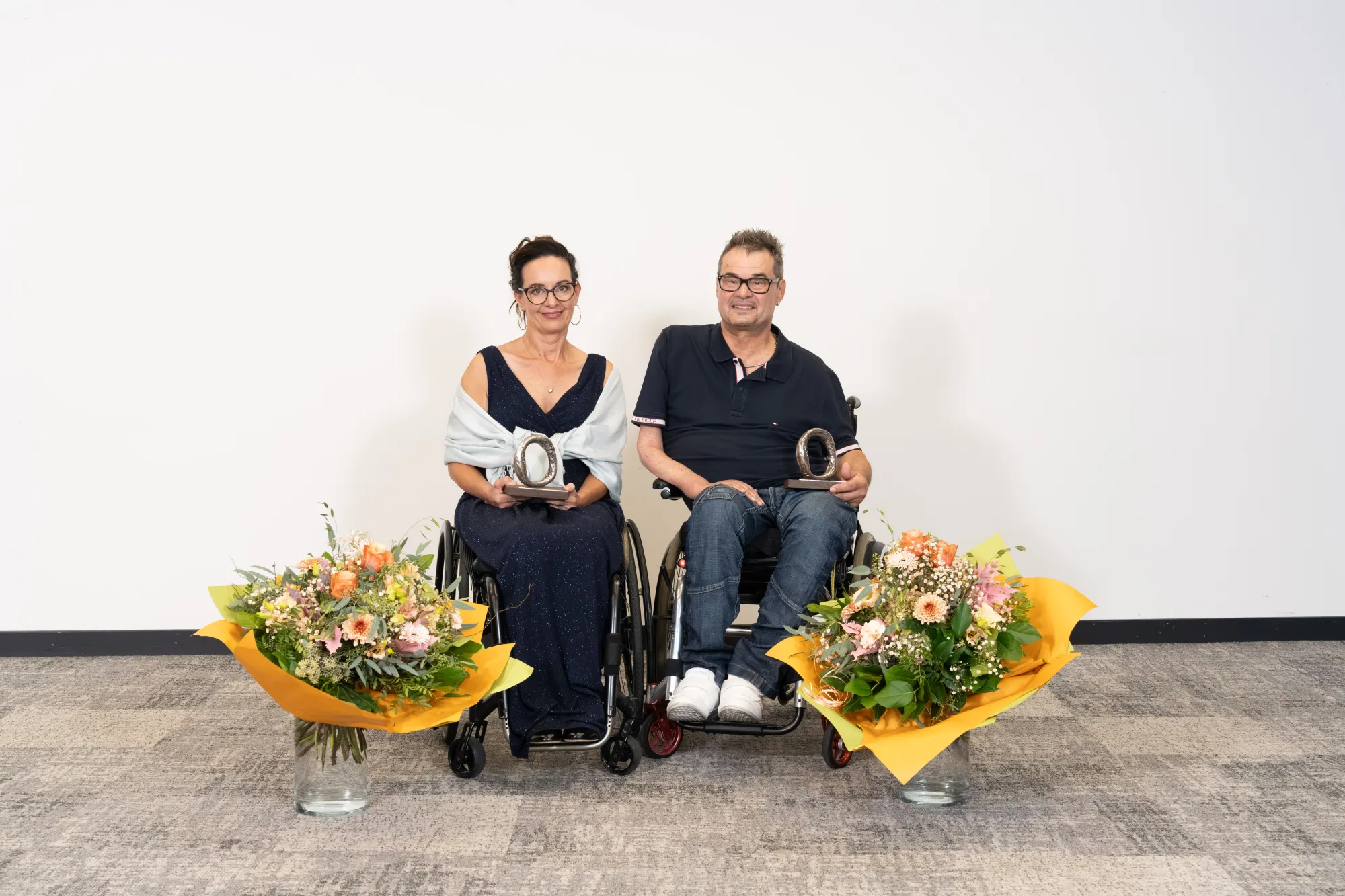 Two people sitting in a wheelchair surrounded by colorful flowers.