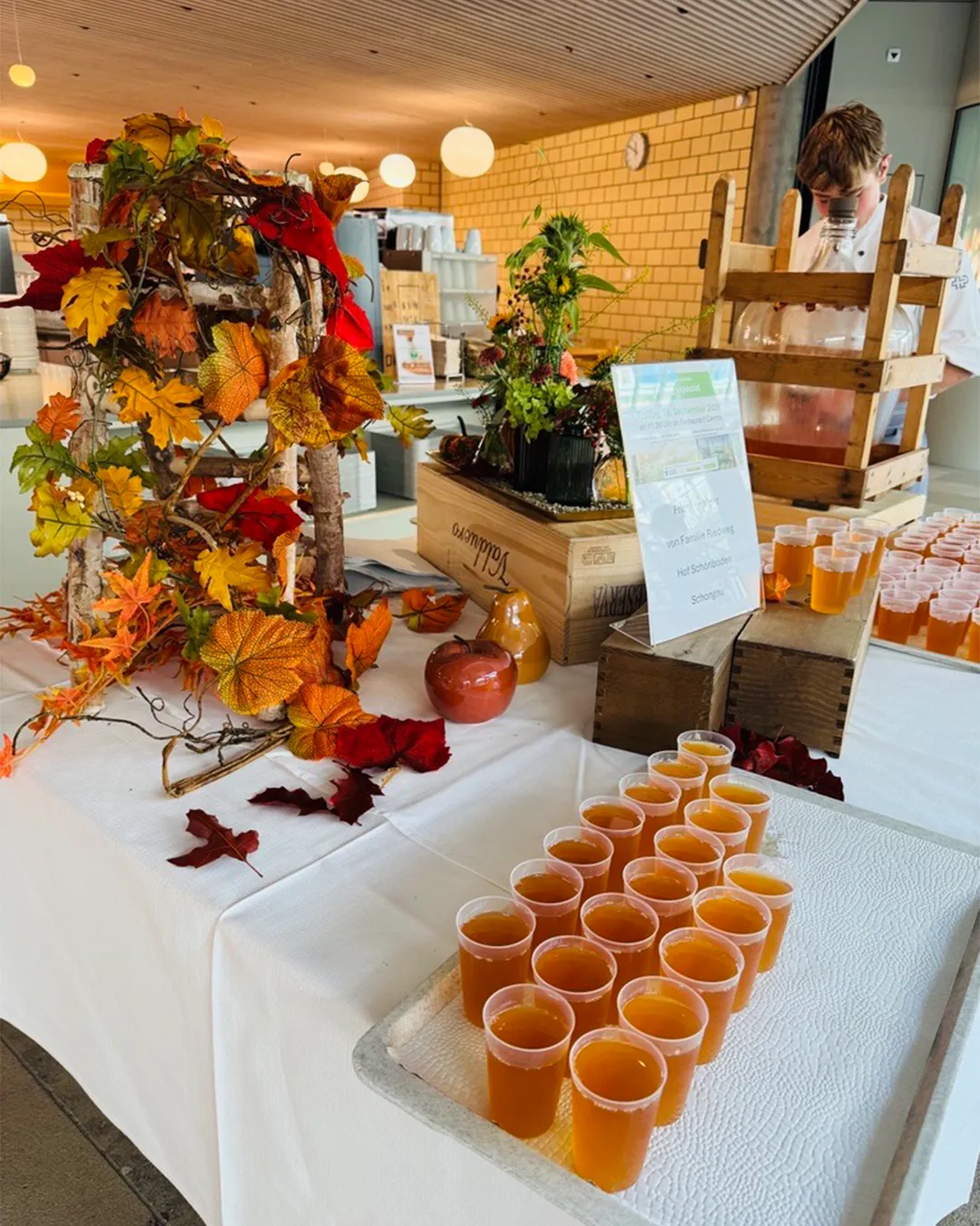 A cozy indoor farmers market-style display with various fruits, vegetables, and other produce items arranged on tables and shelves.