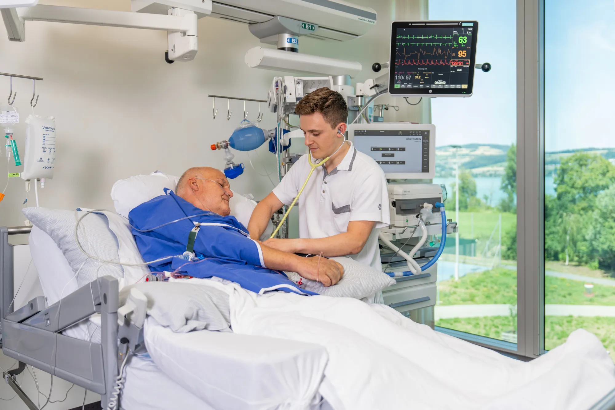A medical professional examining a patient in a hospital room.