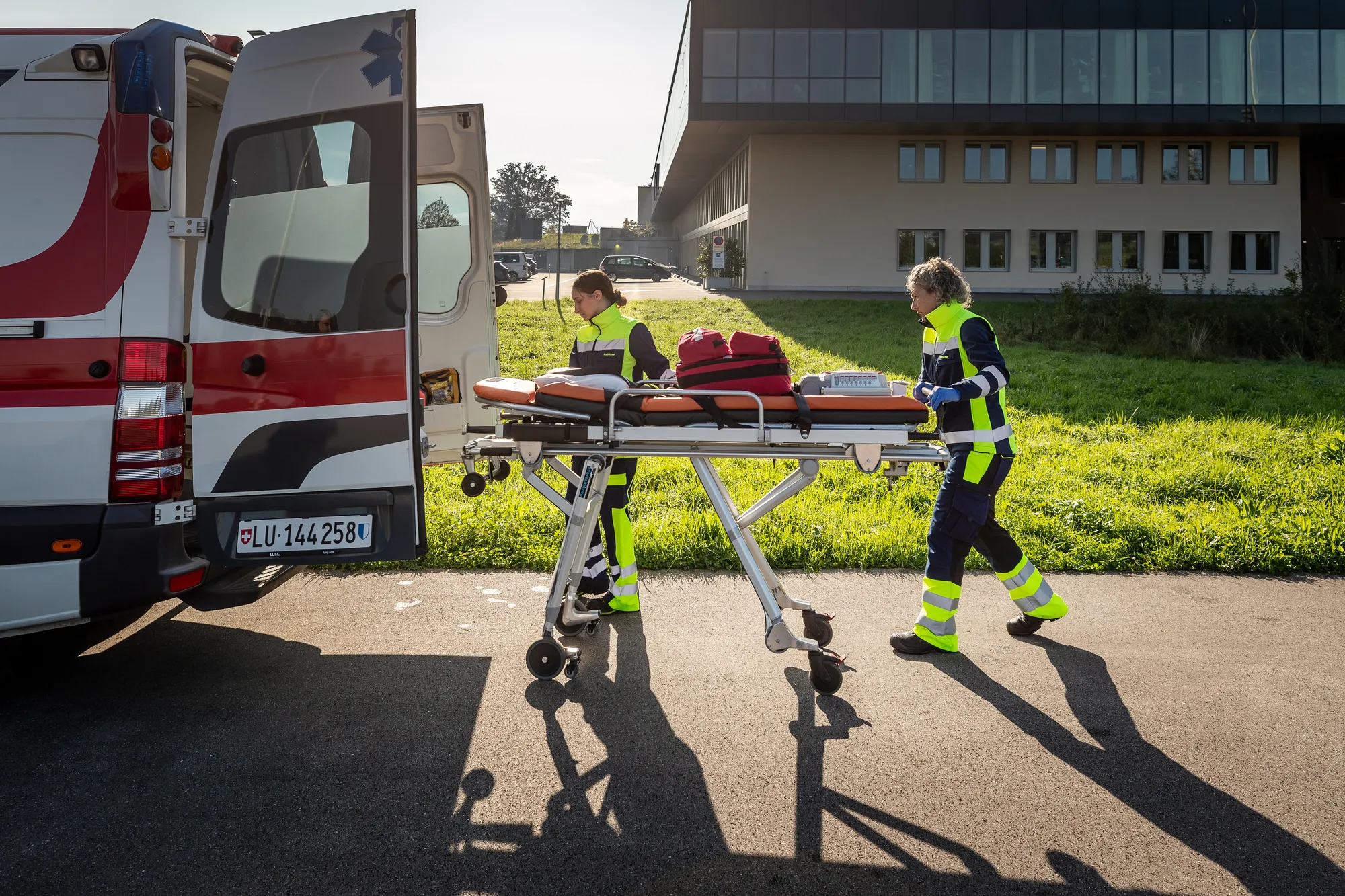 Rettungssanitäterinnen mit einer Trage und der Ambulanz