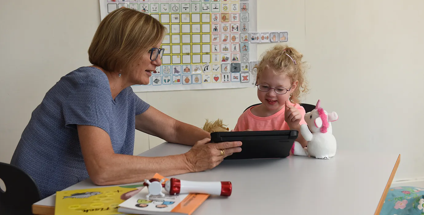 Travailler avec l’aide à la communication procure du plaisir à la fillette.