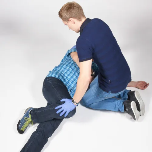 Ersthelfer legt bewusstlose Person in stabile Seitenlage