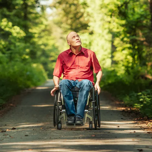 Sebastian Tobler est assise dans son fauteuil roulant dans la foret.