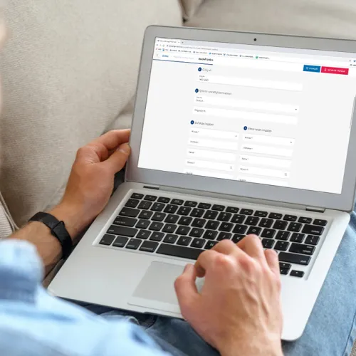 Ein Mann sitzt auf dem Sofa mit dem Laptop auf den Beinen. Auf dem Bildschirm sieht man das Formular für die Adressänderung bei einer Mitgliedschaft bei der Gönner-Vereinigung der Schweizer Paraplegiker-Stiftung.