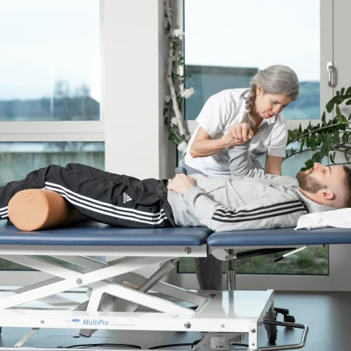 Two people lying on desks, relaxing.
