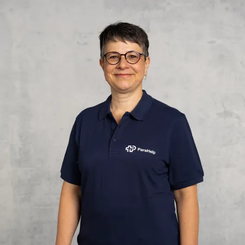Eine Frau in einem blauen Hemd und Brille.