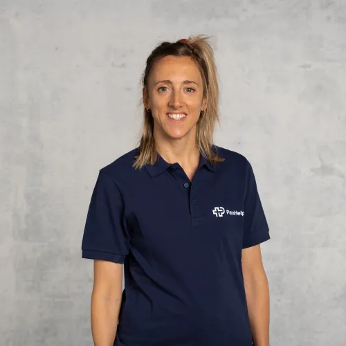 Une femme souriante portant un polo bleu marine avec le logo d'une entreprise.