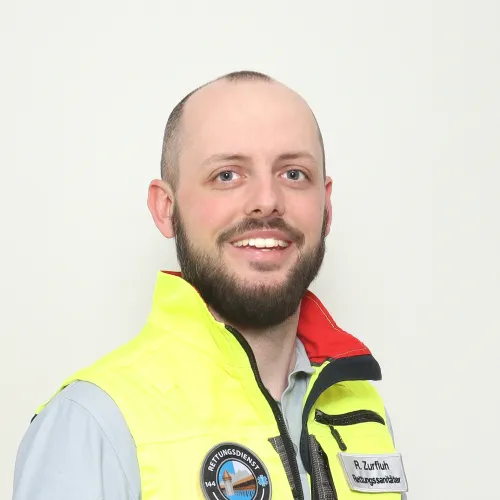 Smiling construction worker wearing yellow safety vest.