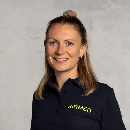 Smiling woman with blonde hair wearing a navy blue shirt or jacket.